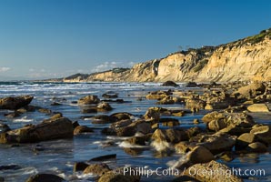 Black's Beach sea cliffs, sunset, looking north from Scripps Pier with Torrey Pines State Reserve in the distance, La Jolla, California