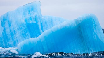 A blue iceberg.  Blue icebergs are blue because the ice from which they are formed has been compressed under such enormous pressure that all gas (bubbles) have been squeezed out, leaving only solid water that takes on a deep blue color. Scotia Sea, Southern Ocean, natural history stock photograph, photo id 24845