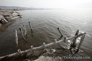 Bombay Beach, lies alongside and below the flood level of the Salton Sea, so that it floods occasionally when the Salton Sea rises.  A part of Bombay Beach is composed of derelict old trailer homes, shacks and wharfs, slowly sinking in the mud and salt, Imperial County, California