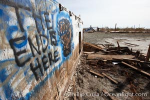 Bombay Beach, lies alongside and below the flood level of the Salton Sea, so that it floods occasionally when the Salton Sea rises.  A part of Bombay Beach is composed of derelict old trailer homes, shacks and wharfs, slowly sinking in the mud and salt, Imperial County, California