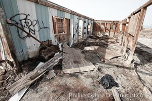 Bombay Beach, lies alongside and below the flood level of the Salton Sea, so that it floods occasionally when the Salton Sea rises.  A part of Bombay Beach is composed of derelict old trailer homes, shacks and wharfs, slowly sinking in the mud and salt, Imperial County, California