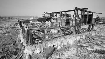 Bombay Beach, lies alongside and below the flood level of the Salton Sea, so that it floods occasionally when the Salton Sea rises.  A part of Bombay Beach is composed of derelict old trailer homes, shacks and wharfs, slowly sinking in the mud and salt, Imperial County, California