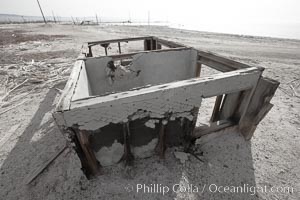 Bombay Beach, lies alongside and below the flood level of the Salton Sea, so that it floods occasionally when the Salton Sea rises.  A part of Bombay Beach is composed of derelict old trailer homes, shacks and wharfs, slowly sinking in the mud and salt, Imperial County, California
