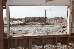 Bombay Beach, lies alongside and below the flood level of the Salton Sea, so that it floods occasionally when the Salton Sea rises.  A part of Bombay Beach is composed of derelict old trailer homes, shacks and wharfs, slowly sinking in the mud and salt, Imperial County, California