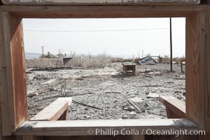 Bombay Beach, lies alongside and below the flood level of the Salton Sea, so that it floods occasionally when the Salton Sea rises.  A part of Bombay Beach is composed of derelict old trailer homes, shacks and wharfs, slowly sinking in the mud and salt, Imperial County, California