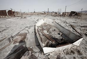 Bombay Beach, lies alongside and below the flood level of the Salton Sea, so that it floods occasionally when the Salton Sea rises.  A part of Bombay Beach is composed of derelict old trailer homes, shacks and wharfs, slowly sinking in the mud and salt, Imperial County, California