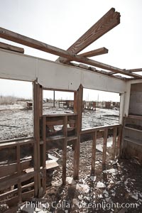 Bombay Beach, lies alongside and below the flood level of the Salton Sea, so that it floods occasionally when the Salton Sea rises.  A part of Bombay Beach is composed of derelict old trailer homes, shacks and wharfs, slowly sinking in the mud and salt, Imperial County, California
