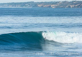 Bodysurfer on large Boomer Beach wave, winter swell, La Jolla, Black's Beach and Torrey Pines in the distance