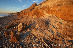 Beach cliffs made of soft clay continually erode, adding fresh sand and cobble stones to the beach.  The sand will flow away with ocean currents, leading for further erosion of the cliffs. Carlsbad, California, USA, natural history stock photograph, photo id 22187