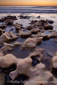 Rocks along the edge of the ocean at sunset, Carlsbad, California