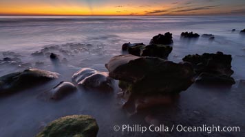 Sunset, sea cliffs, rocks and swirling water blurred in a long time exposure, Carlsbad, California