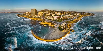 Childrens Pool Aerial Panoramic Photo at Sunset, people enjoying the sunset on the sea wall and the protected beach, Coast Boulevard in the foreground, Mount Soledad in the distance