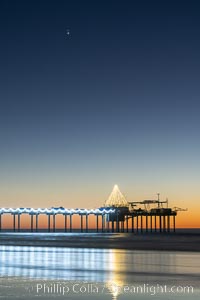 Conjuction of Saturn and Jupiter over Scripps Institution of Oceanography Research Pier at sunset, with Christmas Lights and Christmas Tree, La Jolla, California