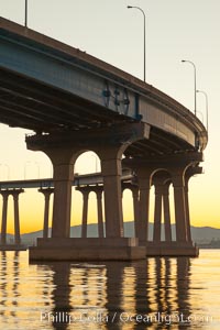 Coronado Bridge, linking San Diego to Coronado, sunrise, viewed from Coronado Island. San Diego Coronado Bridge, known locally as the Coronado Bridge, links San Diego with Coronado, California. The bridge was completed in 1969 and was a toll bridge until 2002. It is 2.1 miles long and reaches a height of 200 feet above San Diego Bay.