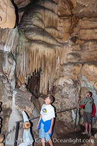 Visitors admire the Pipe Organ formation of calcite flowstone and cave curtains, Crystal Cave, Sequoia Kings Canyon National Park, California