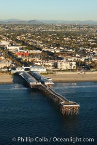 Crystal Pier, 872 feet long and built in 1925, extends out into the Pacific Ocean from the town of Pacific Beach.  Mission Bay and downtown San Diego are seen in the distance