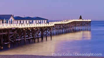 The Crystal Pier and Pacific Ocean at sunrise, dawn, waves blur as they crash upon the sand.  Crystal Pier, 872 feet long and built in 1925, extends out into the Pacific Ocean from the town of Pacific Beach.