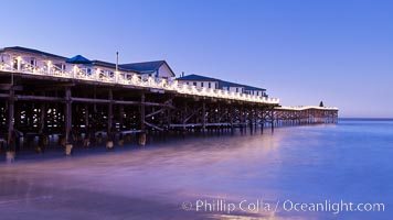 The Crystal Pier and Pacific Ocean at sunrise, dawn, waves blur as they crash upon the sand.  Crystal Pier, 872 feet long and built in 1925, extends out into the Pacific Ocean from the town of Pacific Beach