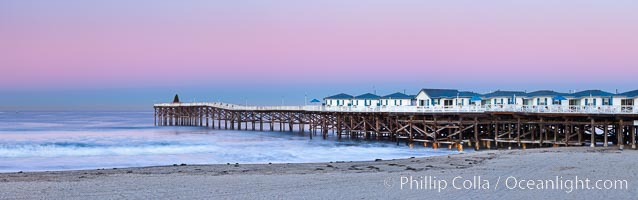 The Crystal Pier and Pacific Ocean at sunrise, dawn, waves blur as they crash upon the sand.  Crystal Pier, 872 feet long and built in 1925, extends out into the Pacific Ocean from the town of Pacific Beach