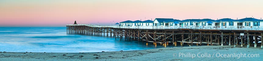 The Crystal Pier and Pacific Ocean at sunrise, dawn, waves blur as they crash upon the sand.  Crystal Pier, 872 feet long and built in 1925, extends out into the Pacific Ocean from the town of Pacific Beach