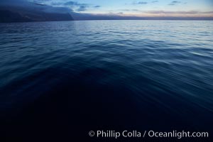 Dark water, clouds at days end, cliffs, sunset.