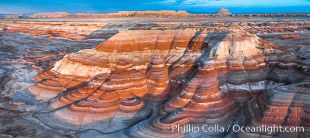 Dawn breaks over the Bentonite Hills in the Utah Badlands.  Striations in soil reveal layers of the Morrison Formation, formed in swamps and lakes in the Jurassic era. Aerial panoramic photograph