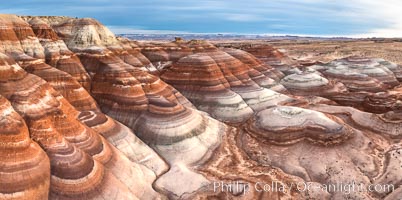 Dawn breaks over the Bentonite Hills in the Utah Badlands.  Striations in soil reveal layers of the Morrison Formation, formed in swamps and lakes in the Jurassic era. Aerial panoramic photograph