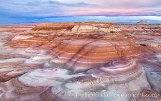 Dawn breaks over the Bentonite Hills in the Utah Badlands.  Striations in soil reveal layers of the Morrison Formation, formed in swamps and lakes in the Jurassic era. Aerial panoramic photograph.