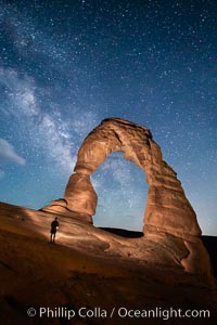 Delicate Arch and Milky Way, lit by quarter moon, hiker's flashlight and the fading blue sky one hour after sunset.  Arches National Park, Utah.