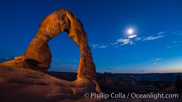 Delicate Arch and the Moon at Sunset.  The moon and clouds, with stars showing faintly in the sky, as sunset fades into night, Arches National Park, Utah