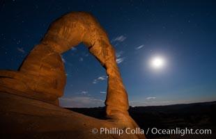 Delicate Arch and the Moon at Sunset.  The moon and clouds, with stars showing faintly in the sky, as sunset fades into night. (Note: this image was created before a ban on light-painting in Arches National Park was put into effect.  Light-painting is no longer permitted in Arches National Park)