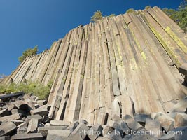 Devil's Postpile, a spectacular example of columnar basalt.  Once molten and under great pressure underground, the lava that makes up Devil's Postpile cooled evenly and slowly, contracting and fracturing into polygonal-sided columns.  The age of the formation is estimated between 100 and 700 thousand years old.  Sometime after the basalt columns formed, a glacier passed over the formation, cutting and polishing the tops of the columns.  The columns have from three to seven sides, varying because of differences in how quickly portions of the lava cooled, Devils Postpile National Monument, California