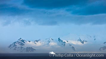 Distant icebergs, mountains, clouds, ocean at dawn, in the South Shetland Islands, near Deception Island.