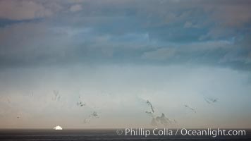 Distant icebergs, mountains, clouds, ocean at dawn, in the South Shetland Islands, near Deception Island