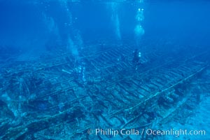 Divers swim over a undersea wreck