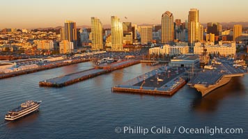 Downtown San Diego bayfront, Marina District, with the USS Midway Navy aircraft carrier (right), cruise ship terminal (left) and high rise office buildings towering over North Harbor Drive along San Diego Bay