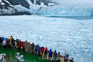 Drygalski Fjord, passengers on icebreaker M/V Polar Star.  The water is packed with brash ice which has broken away from Risting Glacier at the end of the narrow fjord