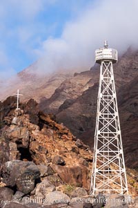 Lighthouse and cross mark the site of a small fishing shack and old chapel and prison near the north end of Guadalupe Island (Isla Guadalupe)