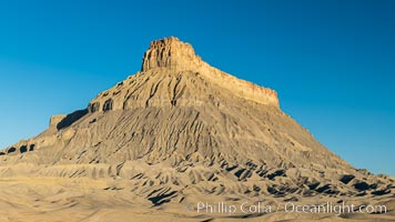 Factory Butte at sunrise. An exceptional example of solitary butte surrounded by dramatically eroded badlands, Factory Butte stands alone on the San Rafael Swell, Hanksville, Utah