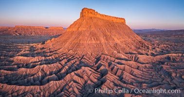Factory Butte at sunrise. An exceptional example of solitary butte surrounded by dramatically eroded badlands, Factory Butte stands alone on the San Rafael Swell, Hanksville, Utah