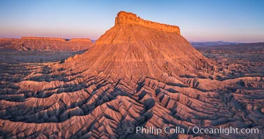 Factory Butte at sunrise. An exceptional example of a solitary butte surrounded by dramatically eroded badlands, Factory Butte stands alone on the San Rafael Swell, Hanksville, Utah