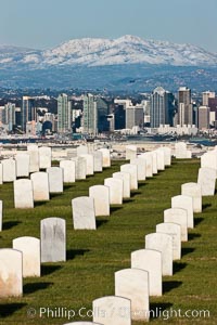 Tombstones at Fort Rosecrans National Cemetery, with downtown San Diego with snow-covered Mt. Laguna in the distance