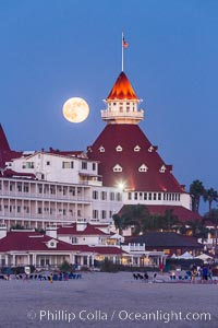 Full Moon Rising over Hotel del Coronado, known affectionately as the Hotel Del. It was once the largest hotel in the world, and is one of the few remaining wooden Victorian beach resorts. It sits on the beach on Coronado Island, seen here with downtown San Diego in the distance. It is widely considered to be one of Americas most beautiful and classic hotels. Built in 1888, it was designated a National Historic Landmark in 1977.