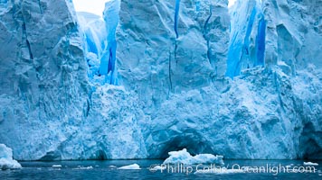 A glacier fractures and cracks, as the leading edge reaches the ocean.  The pieces will float away to become icebergs.