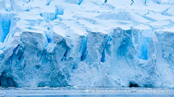 A glacier fractures and cracks, as the leading of a glacier fractures and cracks as it reaches the ocean.  The pieces will float away to become icebergs.