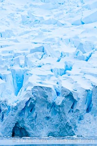 A glacier fractures and cracks, as the leading of a glacier fractures and cracks as it reaches the ocean.  The pieces will float away to become icebergs, Neko Harbor