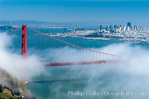 San Franciscos infamous summer fog overtakes the Golden Gate Bridge, viewed from the Marin Headlands with the city of San Francisco visible in the distance