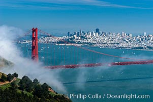 San Franciscos infamous summer fog overtakes the Golden Gate Bridge, viewed from the Marin Headlands with the city of San Francisco visible in the distance