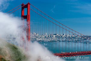 San Franciscos infamous summer fog overtakes the Golden Gate Bridge, viewed from the Marin Headlands with the city of San Francisco visible in the distance