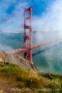 San Franciscos infamous summer fog overtakes the Golden Gate Bridge, viewed from the Marin Headlands with the city of San Francisco visible in the distance